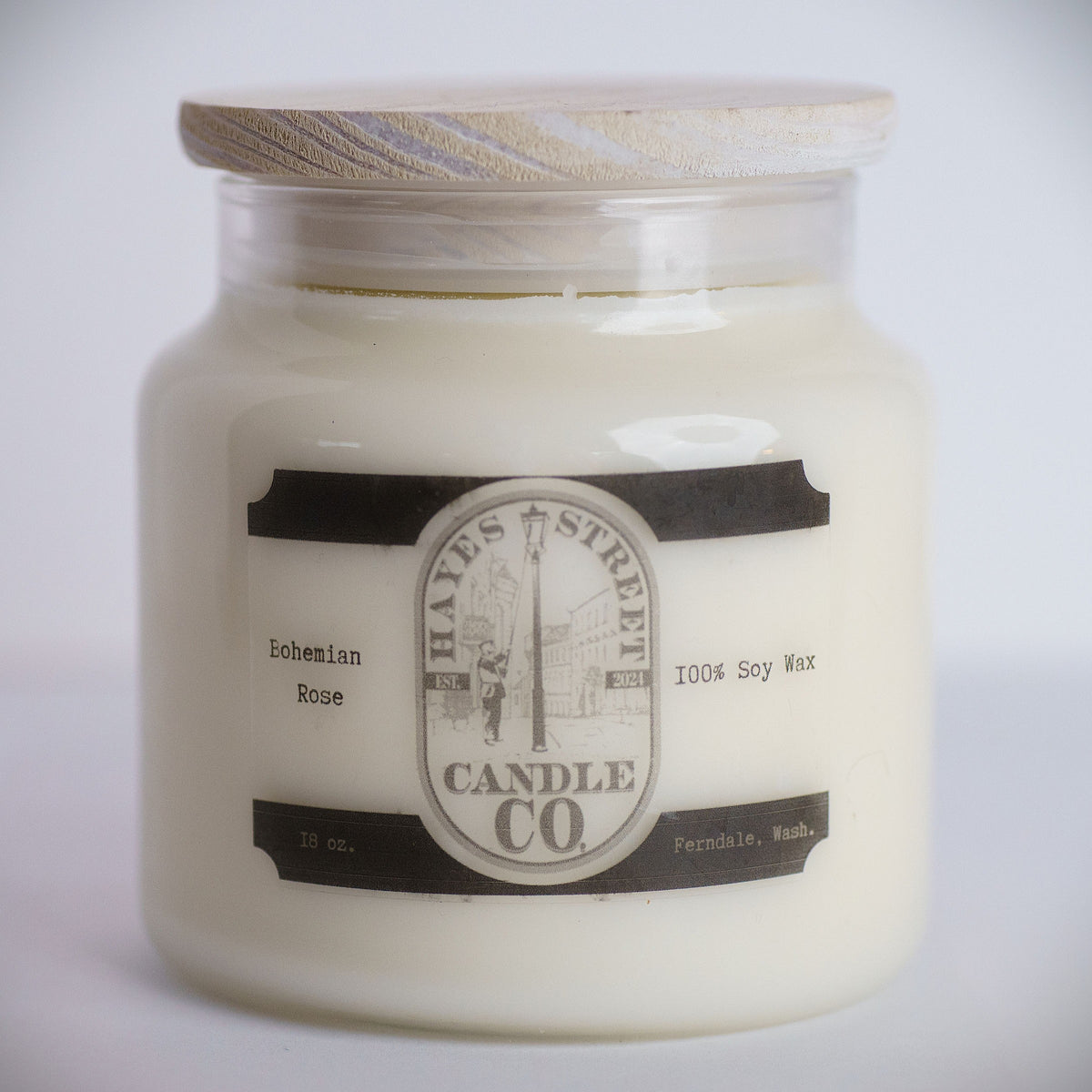 An 18 oz soy wax candle in a clear glass jar with a light wood lid, featuring a vintage-style label for Hayes Street Candle Co. in the Bohemian Rose scent.